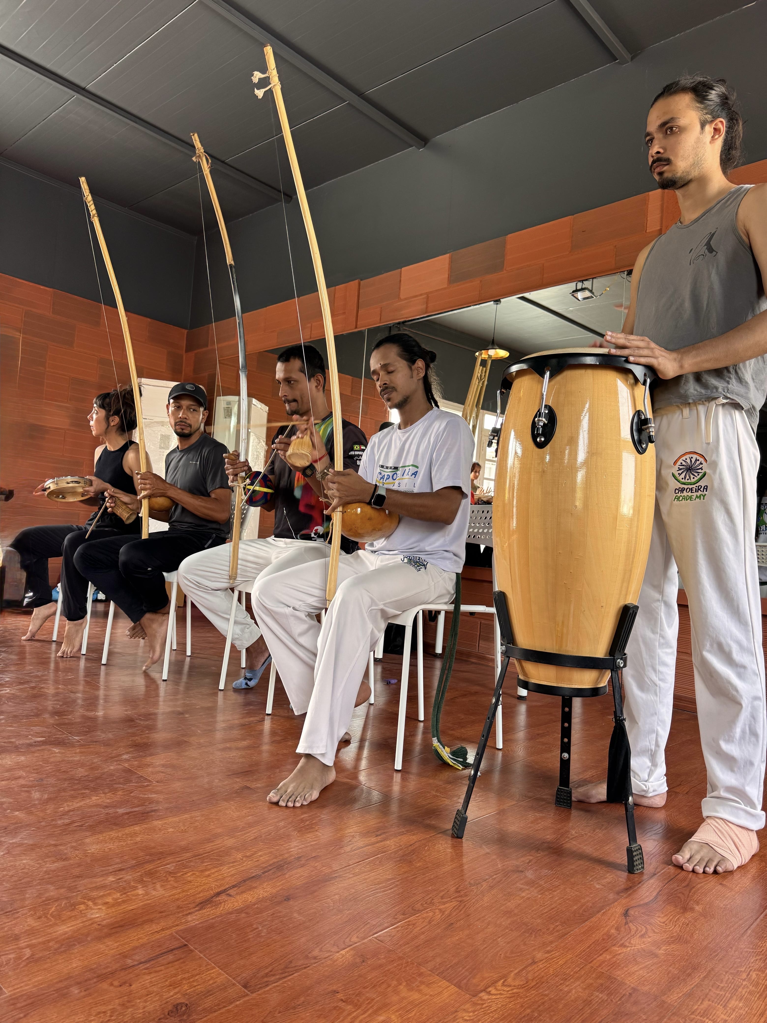 Capoeira musicians playing berimbau and atabaque